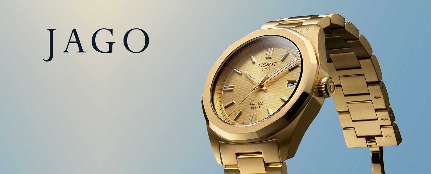 Gold Tissot PRC100 wristwatch on a cream-to-sky gradient backdrop, with the JAGO wordmark to the left.